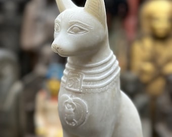 Estatua artesanal de Bastet, la gata diosa egipcia, en piedra blanca.
