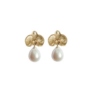 May include: Gold orchid earrings with a pearl drop. The orchid is a delicate floral design.