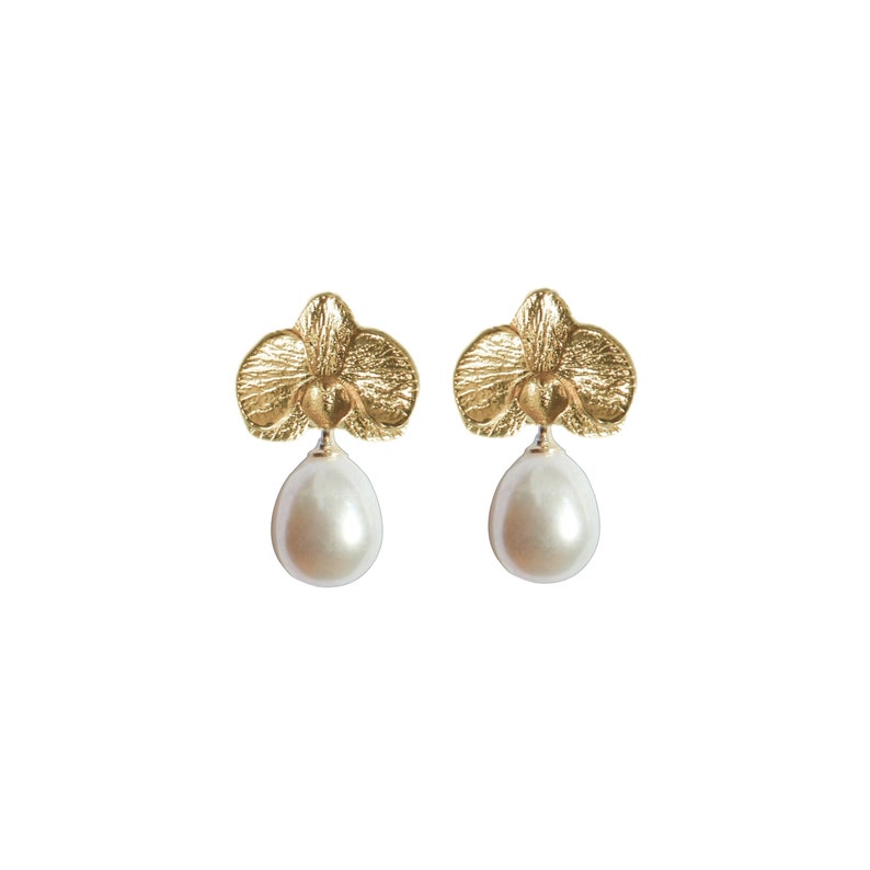 May include: Gold orchid earrings with a pearl drop. The orchid is a delicate floral design.
