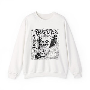 May include: White sweatshirt with a black and white graphic. The graphic features a skull with flames, text that reads "Grimes", and other text in a foreign language. The sweatshirt is a crew neck style.