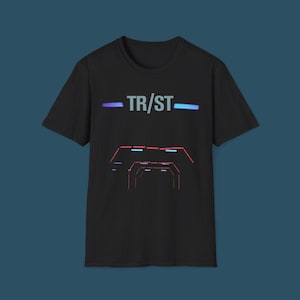 May include: Black t-shirt with the word "TR/ST" in white, with blue and teal horizontal lines above and below the text. Below the text is a graphic of a series of red and blue geometric shapes, resembling a tunnel.