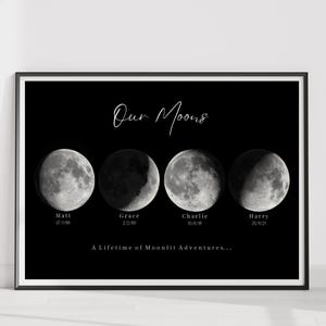 May include: A black framed print featuring four distinct moon phases in grayscale. The text reads Our Moons at the top, with the names Matt, Grace, Charlie, and Harry below each moon, followed by dates and the phrase A Lifetime of Moonlit Adventures.