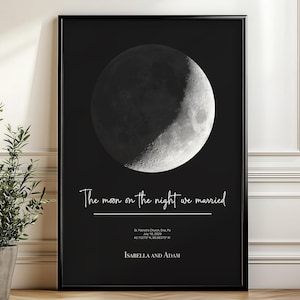 May include: A black rectangular wall art print featuring a detailed white crescent moon graphic. The text reads: The moon on the night we married, St. Patrick's Church, Erie, PA, July 18, 2008, 42.1292° N, 80.0853° W, and the names Isabella and Adam.