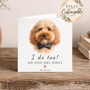 Peut inclure: Une carte de vœux carrée avec une illustration à l'aquarelle d'un chien au pelage bouclé brun doré portant un nœud papillon noir avec le nom Teddy. Le texte indique I do too! MR AND MRS JONES avec un petit cœur rose et 01.10.26.
