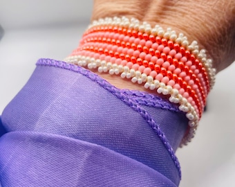 Orange and cream-colored beaded bracelet with button closure