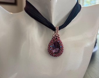 Purple silk necklace with bezeled 25 x 18 pear-shaped light purple crystal pendant