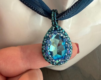 Blue pear shaped bezeled pendant on an ombre blue silk necklace