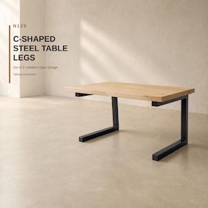 Könnte beinhalten: Ein Set aus zwei schwarzen, C-förmigen Tischbeinen aus Stahl, die eine helle Holzplatte tragen. Das Bild enthält den Text N129 C-SHAPED STEEL TABLE LEGS, Set of 2, Modern Open Design und Tabletop not included in der oberen linken Ecke.