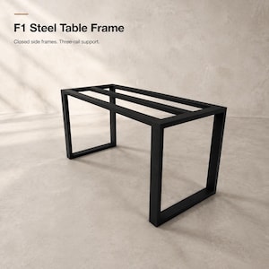 May include: F1 Steel Table Frame with closed side frames and three-rail support. This rectangular black metal structure features a sturdy design with two vertical end supports connected by three horizontal bars across the top surface.