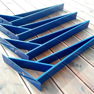 May include: Five blue metal shelf brackets, arranged in a staggered pattern on a wooden surface.