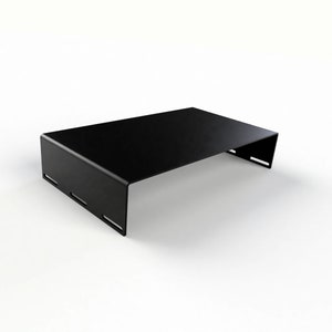 Puede incluir: Una mesa de centro de metal negro con una tapa rectangular y un diseño abierto único en los lados. La mesa está hecha de metal resistente y tiene un aspecto elegante y moderno.
