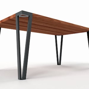 Könnte beinhalten: Ein Holztisch mit rechteckiger Tischplatte und schwarzen Metallbeinen. Die Beine sind angewinkelt und bilden ein V.