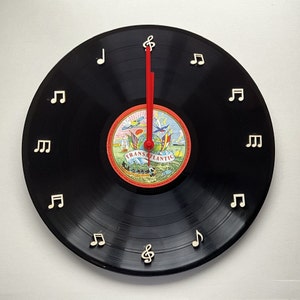 Unique vinyl record wall clock with raised musical notes for numbers crafted from an original 12”vinyl record fully assembled ready to hang