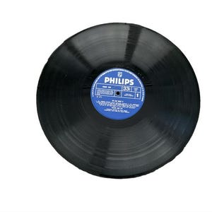 Op de afbeelding: Een zwarte vinylplaat met een blauw label waarop "PHILIPS 331" staat en een lijst met nummers.