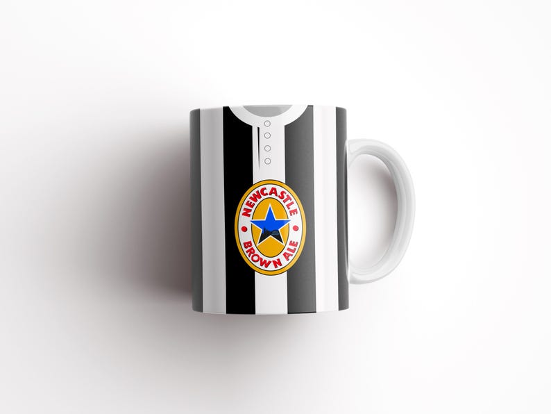 May include: White ceramic mug with a black and white striped design. The mug has a Newcastle Brown Ale logo on the front.