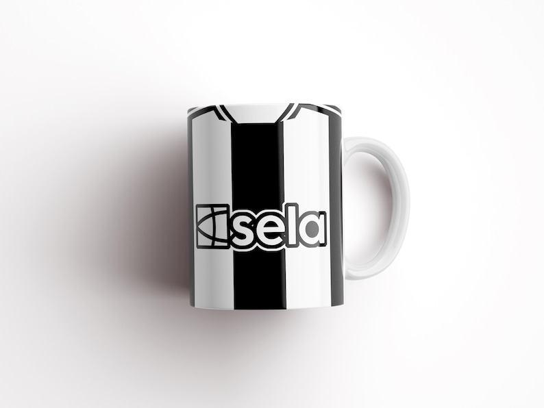 May include: White ceramic mug with a black and white striped design. The mug has a black logo that says "Isela" on the front.