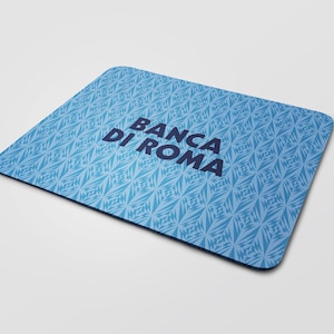 Pode incluir: Um tapete de rato azul com um padrão geométrico branco e o texto "BANCA DI ROMA" em azul escuro.
