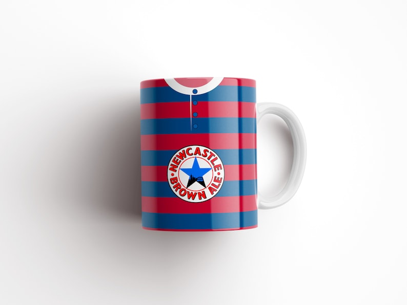 May include: A white ceramic mug with a red and blue striped design. The mug features a circular logo with the text "NEWCASTLE BROWN ALE" and a star.