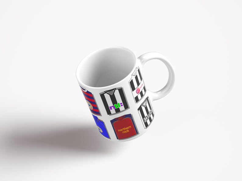 Peut inclure: Une tasse en c&eacute;ramique blanche avec un motif de diff&eacute;rents maillots de football, y compris des maillots ray&eacute;s noir et blanc avec diff&eacute;rents logos et sponsors. Les maillots sont dispos&eacute;s en un motif de collage sur la tasse.