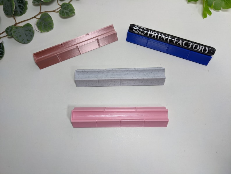 May include: Three different colored plastic molds for making resin crafts. The molds are all rectangular and have a groove down the center. The blue mold has the text "5D PRINT FACTORY" printed on it.