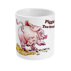 Könnte beinhalten: Weiße Keramiktasse mit einer Cartoon-Illustration eines rosa Schweins, das mit einem gelben Eimer rennt, der ihm aus dem Maul fällt. Der Text "Piggin' Tea-break" ist in Braun auf die Tasse gedruckt.