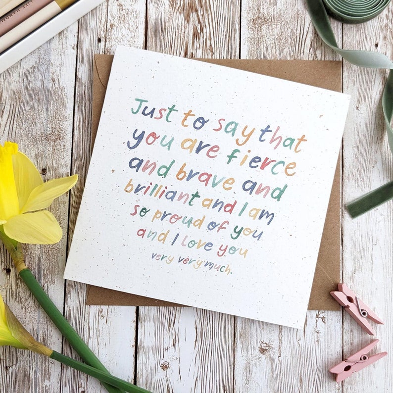 May include: A card with a colorful handwritten message that reads "Just to say that you are fierce and brave and brilliant and I am so proud of you. and I love you very very much."