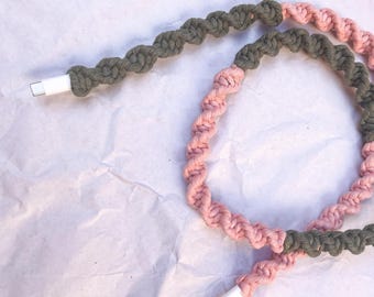 May include: A braided charging cable with a green and pink color scheme. The cable is coiled and ready to be used.