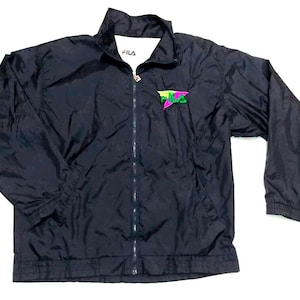 May include: Black FILA jacket with a full-length zipper and a small logo on the chest. The logo is a stylized design in neon green, pink, and yellow. The jacket has a stand-up collar and elastic cuffs.