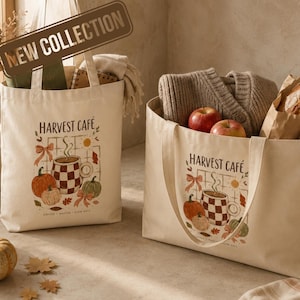 Op de afbeelding: Twee off-white canvas draagtassen met een Harvest Cafe-opdruk met een geblokte mok, pompoenen en herfstbladeren. De tekst luidt Harvest Cafe, Coffee, Matcha, Slow Days. De ene tas staat rechtop, de andere bevat een gebreide trui en appels.