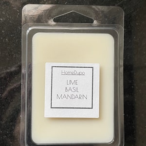 May include: A white wax melt in a clear plastic container with a label that reads "HomeDupo Lime Basil Mandarin"