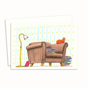 Biglietto d'auguri "Gatto Libresco" - Illustrazione disegnata a mano di un gatto accogliente su una poltrona circondato da libri - Interno vuoto