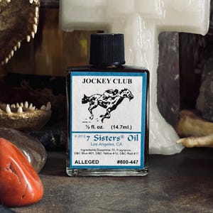 May include: A small glass bottle of "Jockey Club" oil with a black cap. The label features a black and white illustration of a horse and jockey. The bottle contains 1/2 fl. oz. (14.7ml) of oil and is from 7 Sisters Oil, Los Angeles, CA.