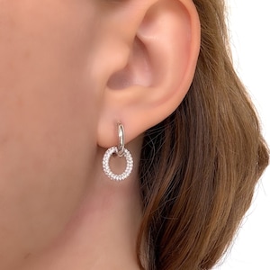 Puede incluir: Pendientes de aro de plata con un pequeño círculo de diamantes engastados en pavé que cuelgan de la parte inferior.
