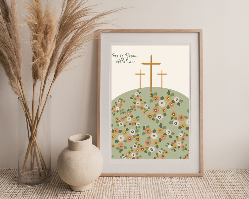 K&ouml;nnte beinhalten: Ein digitaler Kunstdruck mit einem gr&uuml;nen H&uuml;gel und drei goldenen Kreuzen. Der Text "He is Risen, Alleluia" ist oben auf dem Druck in einer Schreibschrift geschrieben. Der H&uuml;gel ist mit einem Muster aus orangefarbenen, wei&szlig;en und blauen Blumen bedeckt.