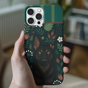 May include: A dark green phone case featuring a black dog illustration with yellow eyes, surrounded by floral and acorn designs. The top section has vertical green stripes. The case is held in a hand.
