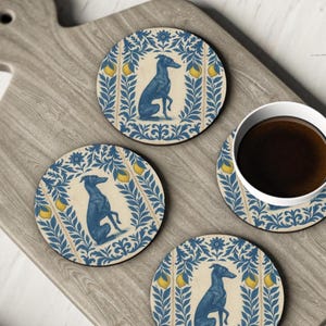 May include: Set of four round coasters with a blue greyhound dog design. Each coaster features a cream background with blue floral and lemon accents. A white coffee cup with dark liquid sits on one coaster.
