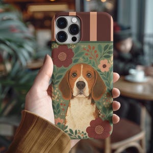 May include: A phone case featuring a beagle dog illustration. The case has a brown top with vertical stripes, a green middle section with floral accents, and a detailed dog portrait. The design includes burgundy and peach-colored flowers.