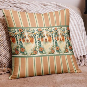 May include: A decorative throw pillow featuring a repeating pattern of an Australian Shepherd dog portrait surrounded by floral elements. The pillow has a striped background in shades of orange and green, adding a touch of rustic charm to home decor.