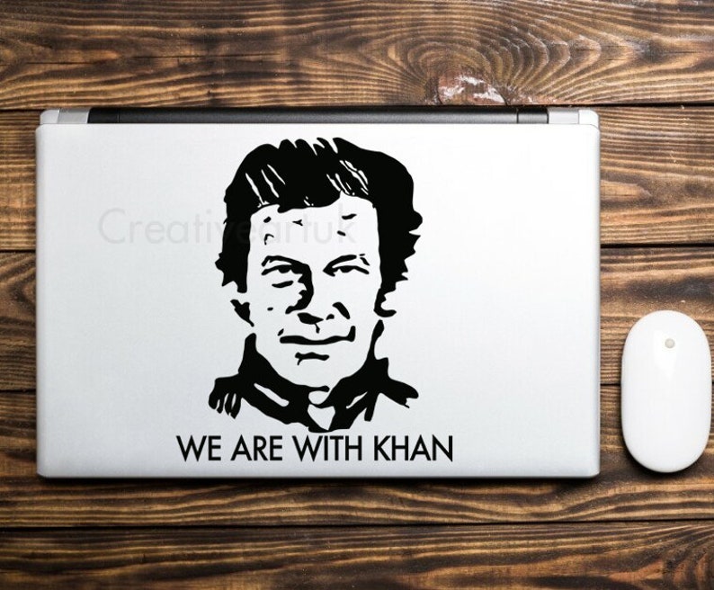 May include: Black and white sticker of a man's face with the text "WE ARE WITH KHAN" on a laptop.