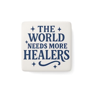 Può includere: Una piastrella quadrata in ceramica bianco sporco con il testo blu navy "THE WORLD NEEDS MORE HEALERS". Il testo è disposto su tre righe con stelle e riccioli decorativi. La piastrella è centrata su uno sfondo bianco.