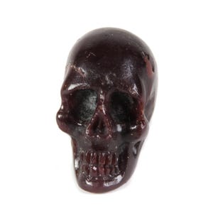 May include: A dark purple skull made of resin. The skull has a detailed design with visible teeth and eye sockets.