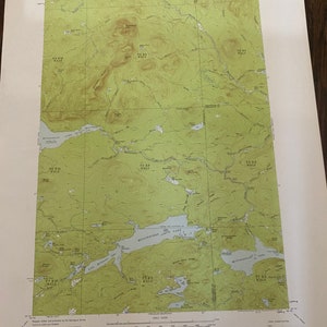 May include: A topographic map of Millinocket Lake, Maine, showing the surrounding area with green and brown contour lines. The map includes a scale, legend, and compass rose. The map is titled "Millinocket Lake, ME" and is dated 1984.