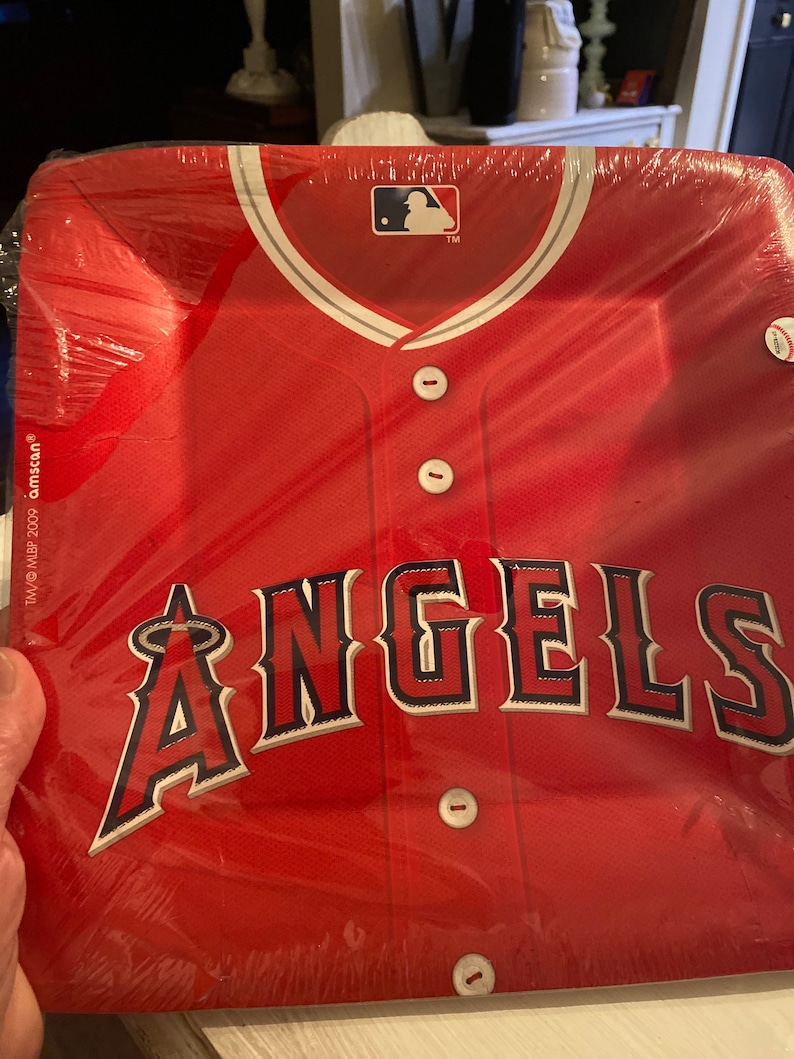 May include: Red and white baseball jersey paper plate with the word "ANGELS" in black and white lettering. The MLB logo is in the top center of the plate.