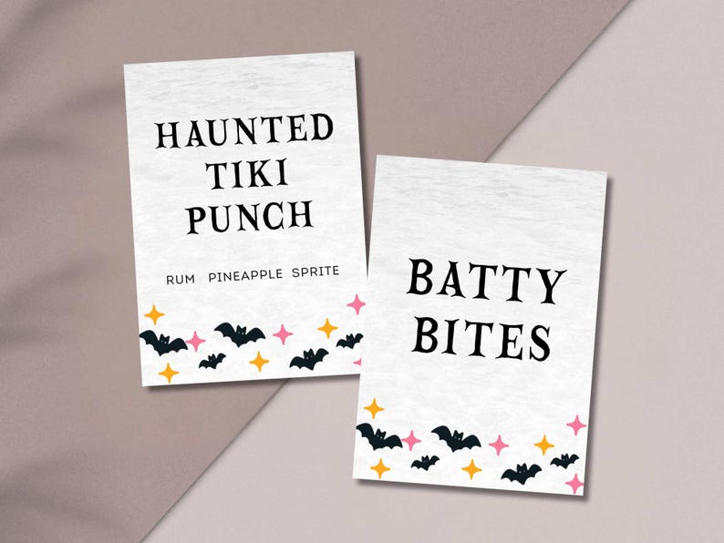 May include: Two white rectangular signs with black text. One reads "HAUNTED TIKI PUNCH" and the other "BATTY BITES". Both have a border of bats, stars, and orange and pink accents, perfect for Halloween.