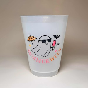 May include: A translucent plastic cup with a "Summerween" design. The design features a cartoon ghost wearing sunglasses and holding a popsicle, with an orange umbrella and bats. The text "Summerween" is in pink and orange.