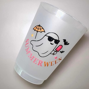 May include: A clear plastic cup with a "Summerween" design. The design features a ghost wearing sunglasses, holding a popsicle, and an umbrella. The text "Summerween" is in pink and orange.
