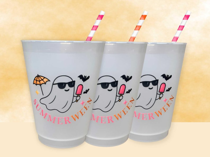 May include: Three white plastic cups with a ghost graphic wearing sunglasses and holding a popsicle. The cups have the word "SUMMERWEEN" in pink, with a striped straw. A bat and umbrella are also featured.