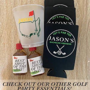 May include: A set of golf-themed party supplies featuring a white plastic cup with a green golf course design and the name "Jason" in yellow letters, two small bottles with "Best Shot of the Day!" labels, and four black can coolers with the text "Let's Par Tee Jason's Bachelor Weekend" in white.