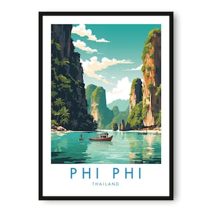 Op de afbeelding: Een ingelijste kunstdruk van Phi Phi, Thailand. De afbeelding toont een serene turquoise baai met torenhoge rotsformaties bedekt met weelderig groen. Een kleine boot drijft op het water en de lucht is een mix van blauw en wit.