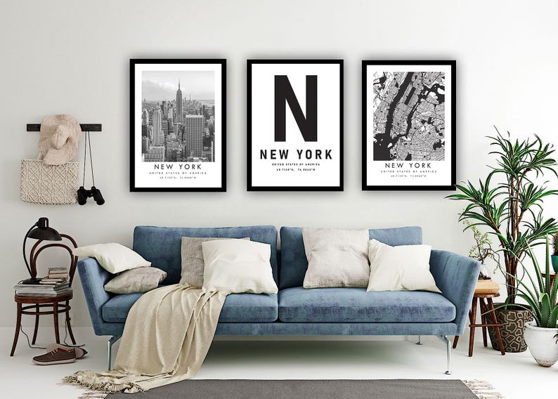 a living room with a blue sofa, a potted plant, and three framed pictures of New York City.